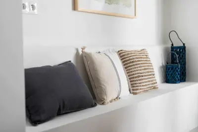 a shelf with pillows on a white wall at Exclusivo Loft con terraza en Ciudad Artes y Cienc in Valencia