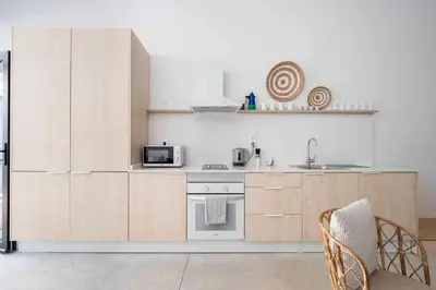 a kitchen with white walls and wooden cabinets at Exclusivo Loft con terraza en Ciudad Artes y Cienc in Valencia