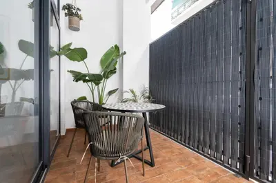 a table and chairs on a balcony with plants at Exclusivo Loft con terraza en Ciudad Artes y Cienc in Valencia
