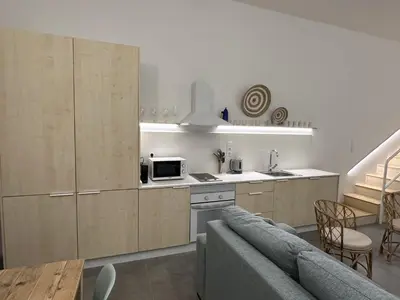 a kitchen with wooden cabinets and a couch in a room at Exclusivo Loft con terraza en Ciudad Artes y Cienc in Valencia