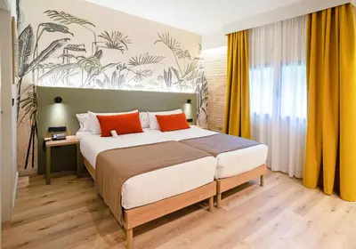a bedroom with a large bed with orange pillows at DWO Valencia in Valencia