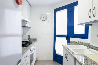 a kitchen with a sink and a blue door at ApartUP Patacona Oriental in Valencia