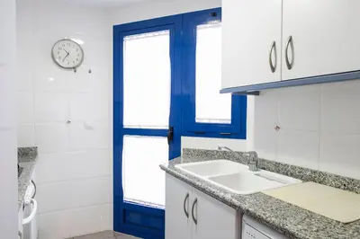 a bathroom with a sink and a blue door at ApartUP Patacona Oriental in Valencia