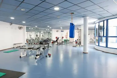 a gym with tables and chairs in a large room at ApartUP Patacona Oriental in Valencia