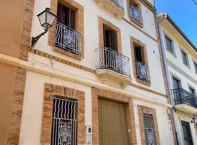 a building with doors and balconies and a gate at Casa Rural Frigols in Chella