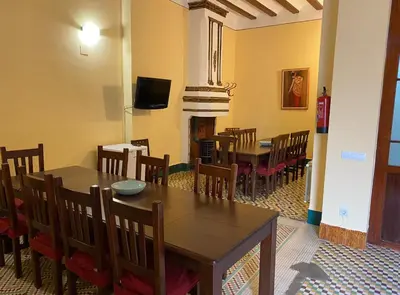 a dining room with a table and chairs and a fireplace at Casa Rural Frigols in Chella