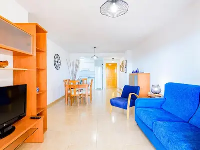 a living room with a blue couch and a tv at Apartment Jardimar by Interhome in Moncófar