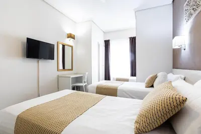 a hotel room with two beds and a tv at Sweet Hotel Continental in Valencia
