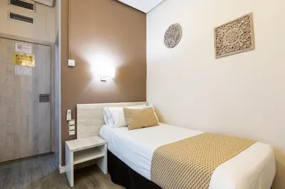 a small room with a bed and a door at Sweet Hotel Continental in Valencia