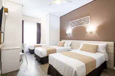 a hotel room with three beds in a room at Sweet Hotel Continental in Valencia