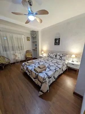 a bedroom with a large bed and a ceiling fan at Estrella azul/ Blue star in Puerto de Sagunto