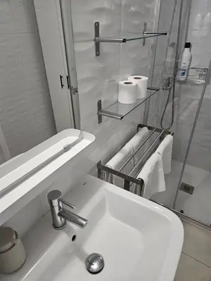 a white bathroom with a sink and a shower at Alojame Valencia in Valencia