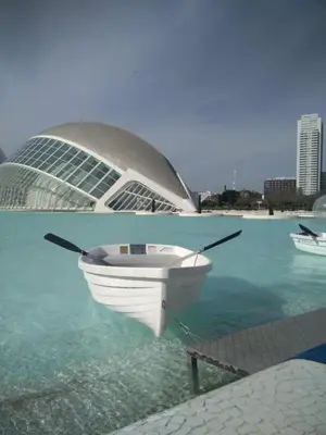 a boat in the water in front of a building at Alojame Valencia in Valencia