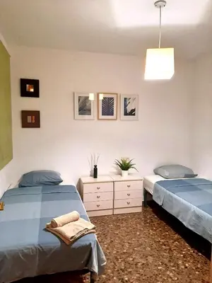 a bedroom with two twin beds and a light at UIM Mediterraneo M Cristina con garaje Wifi in Puerto de Sagunto