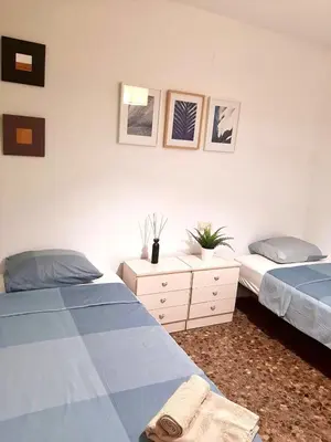 a bedroom with two beds and a dresser with two beds at UIM Mediterraneo M Cristina con garaje Wifi in Puerto de Sagunto