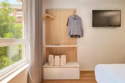 a room with a window and a tv and a shelf at Rooms Ciencias in Valencia