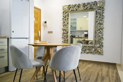 a dining room with a table and chairs and a mirror at Anka Beach Apartment Patacona in Valencia