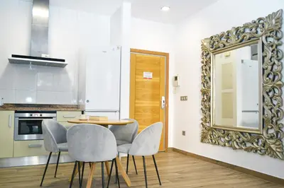 a kitchen with a table and chairs and a mirror at Anka Beach Apartment Patacona in Valencia