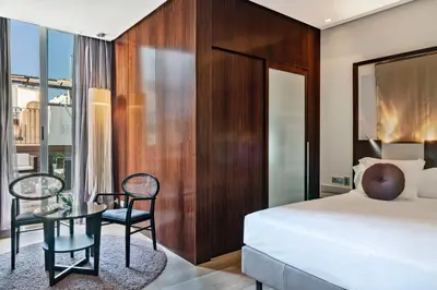 a bedroom with a bed and a table and chairs at Vincci Palace in Valencia