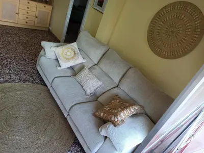 a couch in a living room with pillows on it at Apartamento en Serra con preciosas vistas. in Serra