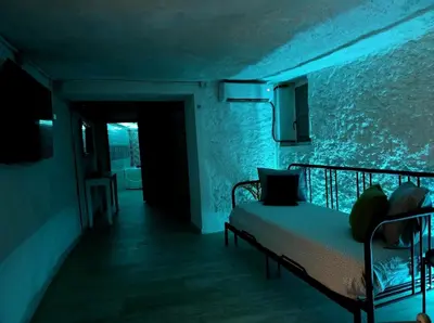 a bedroom with a bed in a dark room at BONITA CASA CUEVA CON JACUZZI in Paterna