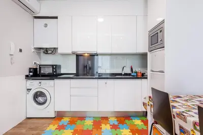 a kitchen with white cabinets and a colorful floor at Piso en la Playa, Wifi gratis y AC in Valencia