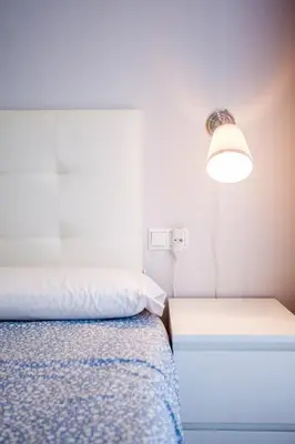 a bedroom with a bed and a light and a lamp at Piso en la Playa, Wifi gratis y AC in Valencia