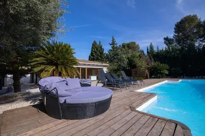 a wooden deck with chairs next to a swimming pool at Villa Huerta 2, Paterna, jacuzzi, sauna in Paterna