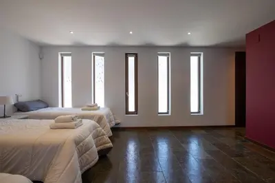 a room with two beds with windows in it at Villa Huerta 2, Paterna, jacuzzi, sauna in Paterna