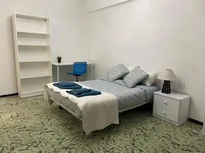 a bedroom with a bed and a blue chair at Casa en Puerto de Sagunto. Playa in Canet de Berenguer