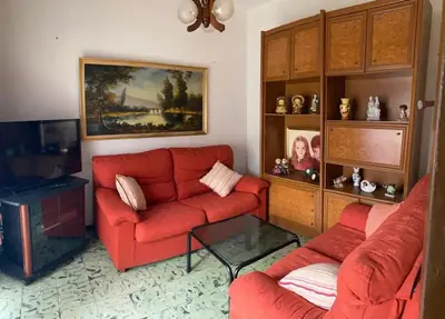 a living room with a red couch and a table at Casa en Puerto de Sagunto. Playa in Canet de Berenguer