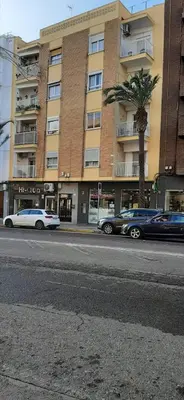 a street with cars parked in front of a building at Casa en Puerto de Sagunto. Playa in Canet de Berenguer