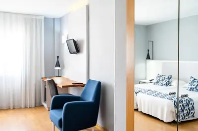 a bedroom with a bed and a desk and a chair at Hotel Beleret in Valencia