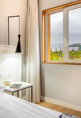 a bedroom with a bed with a table and a window at Hotel Beleret in Valencia