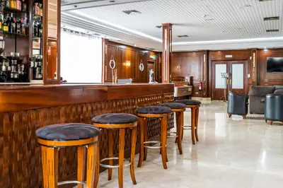 a bar with wooden bar stools in a room at Hotel Beleret in Valencia