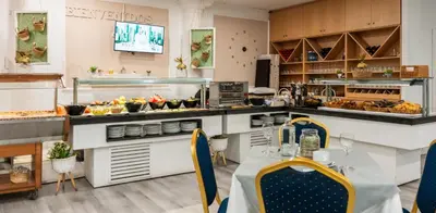 a restaurant with a table and a counter with food at Hotel Beleret in Valencia