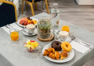 a table with plates of breakfast foods and orange juice at Hotel Beleret in Valencia