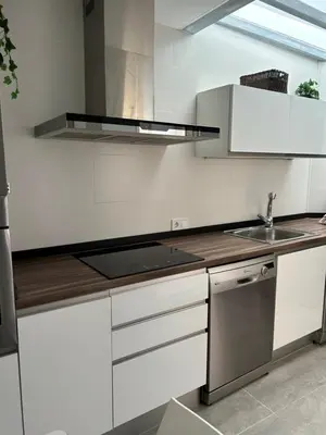 a white kitchen with a sink and a stove at Acogedora y moderna casa en pueblo in Serra