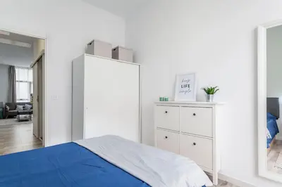 a white bedroom with a bed and a dresser at Apartamento nuevo cerca de la playa y del centro in Valencia