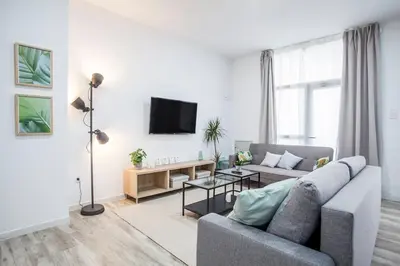 a living room with a couch and a tv at Apartamento nuevo cerca de la playa y del centro in Valencia