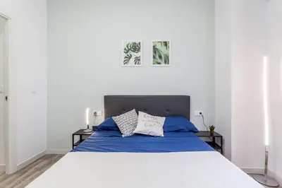 a bedroom with a large bed with blue sheets at Apartamento nuevo cerca de la playa y del centro in Valencia