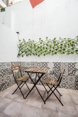 a table and two chairs in front of a wall at Apartamento nuevo cerca de la playa y del centro in Valencia