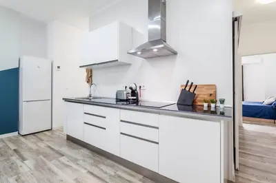 a kitchen with white cabinets and a refrigerator at Apartamento nuevo cerca de la playa y del centro in Valencia