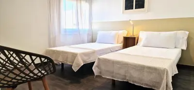 a room with two beds and a chair and a window at Dionis Silence in Valencia