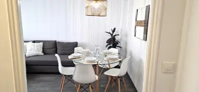 a dining room table with white chairs and a couch at Dionis Silence in Valencia