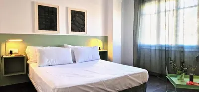 a bedroom with a bed with white sheets and a window at Dionis Silence in Valencia