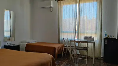 a hotel room with two beds and a table and chairs at Pensión Benavente AP-7 3min coche Playa 5 min Self check-in 24h in Moncófar