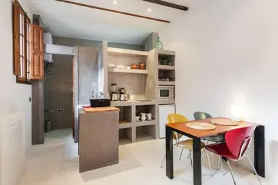 a kitchen with a table and chairs in a room at Casita artista en bello edificio barrio Ruzafa in Valencia