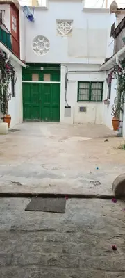 a building with green doors in a parking lot at Casita artista en bello edificio barrio Ruzafa in Valencia