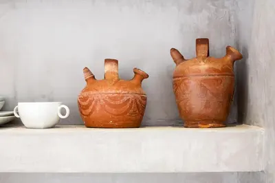 two brown vases sitting on a shelf with a cup at Casita artista en bello edificio barrio Ruzafa in Valencia